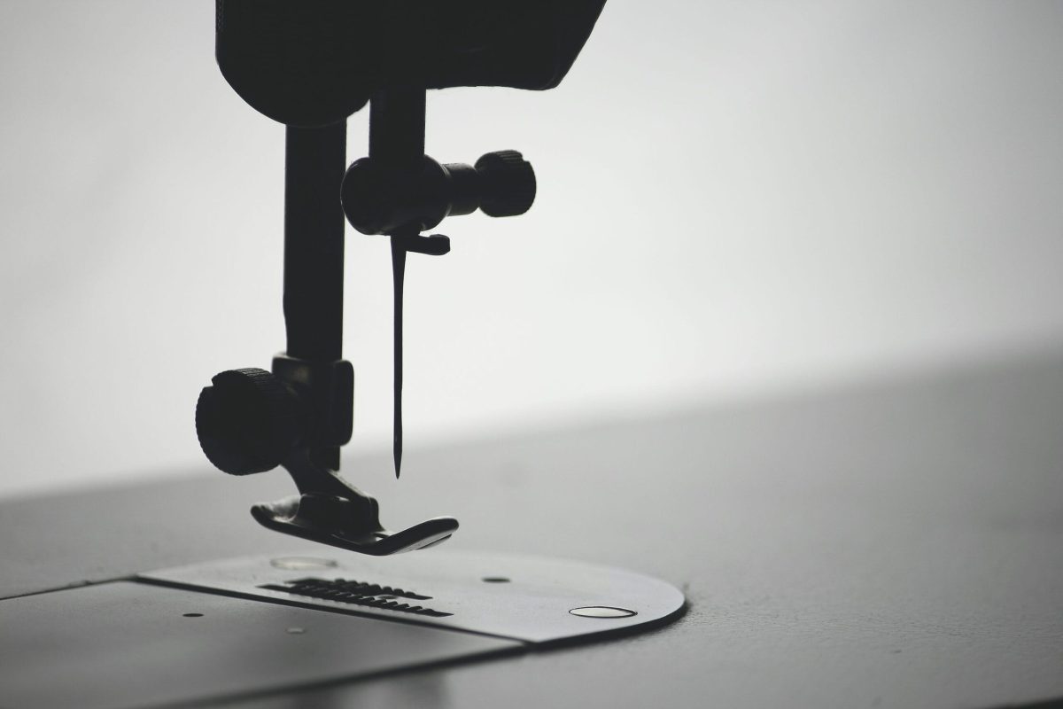 A black-and-white macro photo of a sewing machine needle
