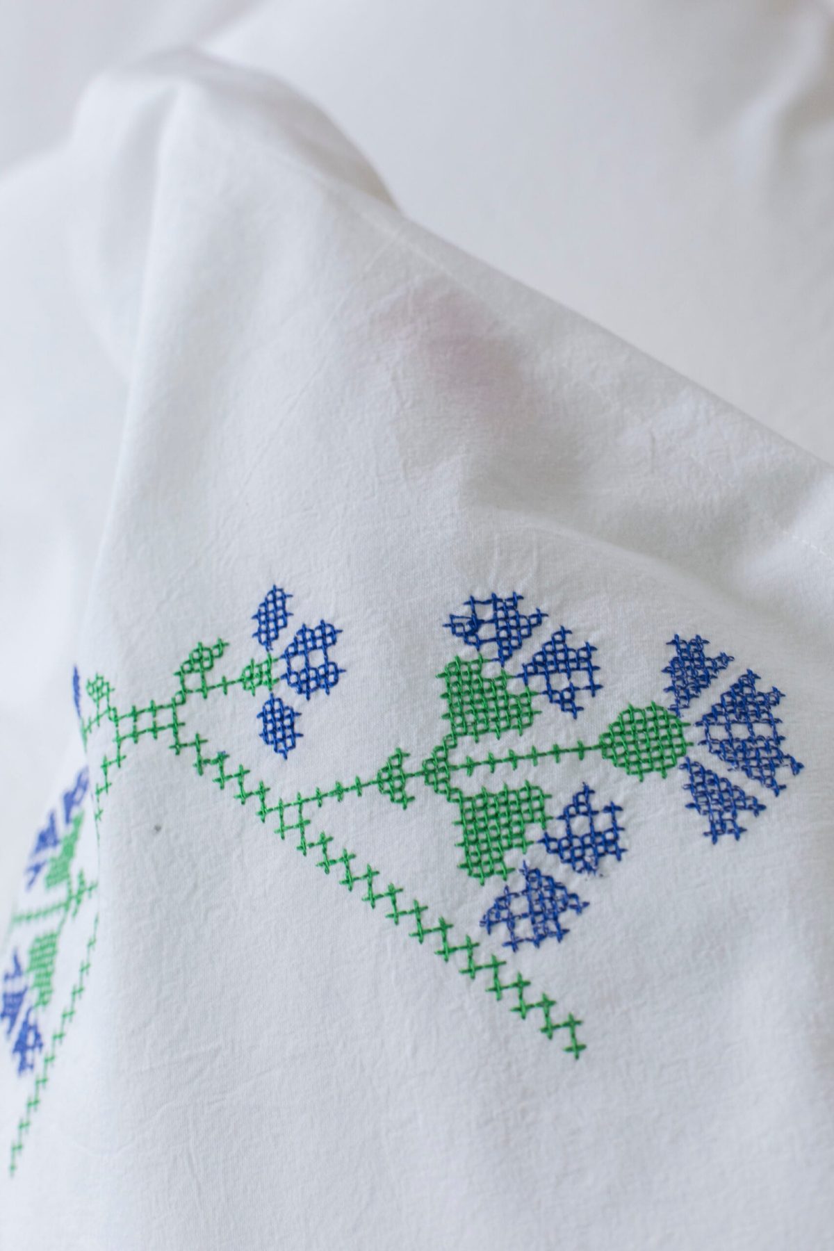 Close-up of a blue chicory flower embroidered on a pillowcase