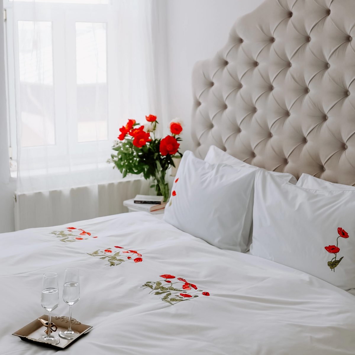lenjerie alba de lux din bumbac percale brodata cu maci intr-un dormitor mic frumos