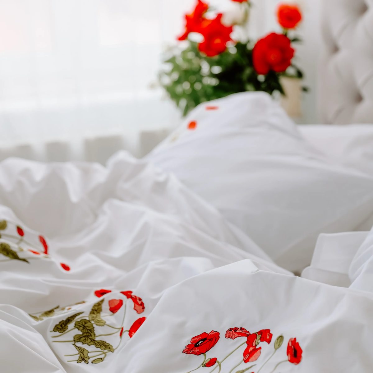 lenjerie alba de lux din bumbac percale brodata cu maci intr-un dormitor mic frumos